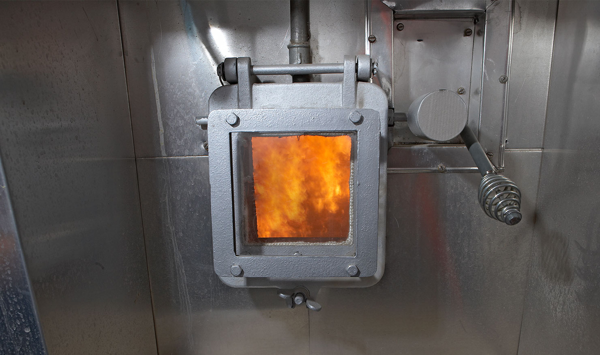 Blick in einen Brennraum mit offenem Feuer – Symbol für Klimaschutz