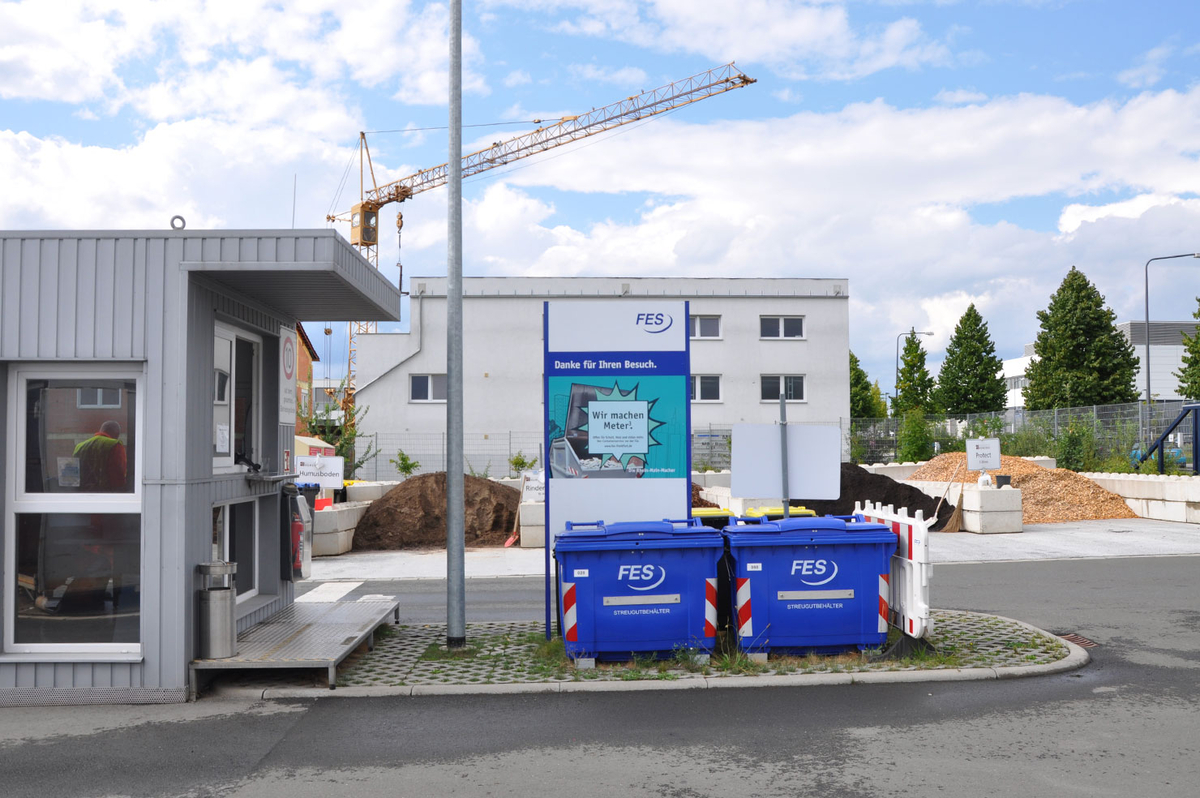 Eingang des Wertstoffhofs Nord mit Containern und Fahrzeugen